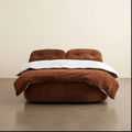 Brown upholstered bed with white bedding on a beige background